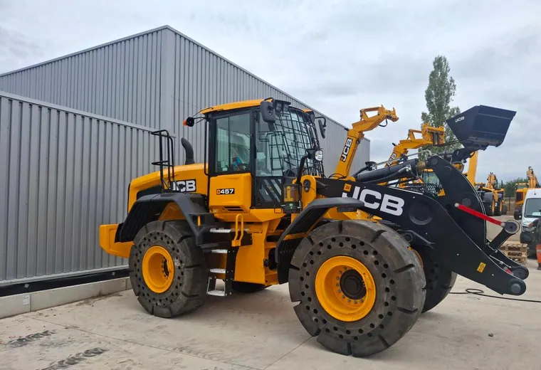 Chargeuse JCB et ses pneumatiques devant un bâtiment d’atelier